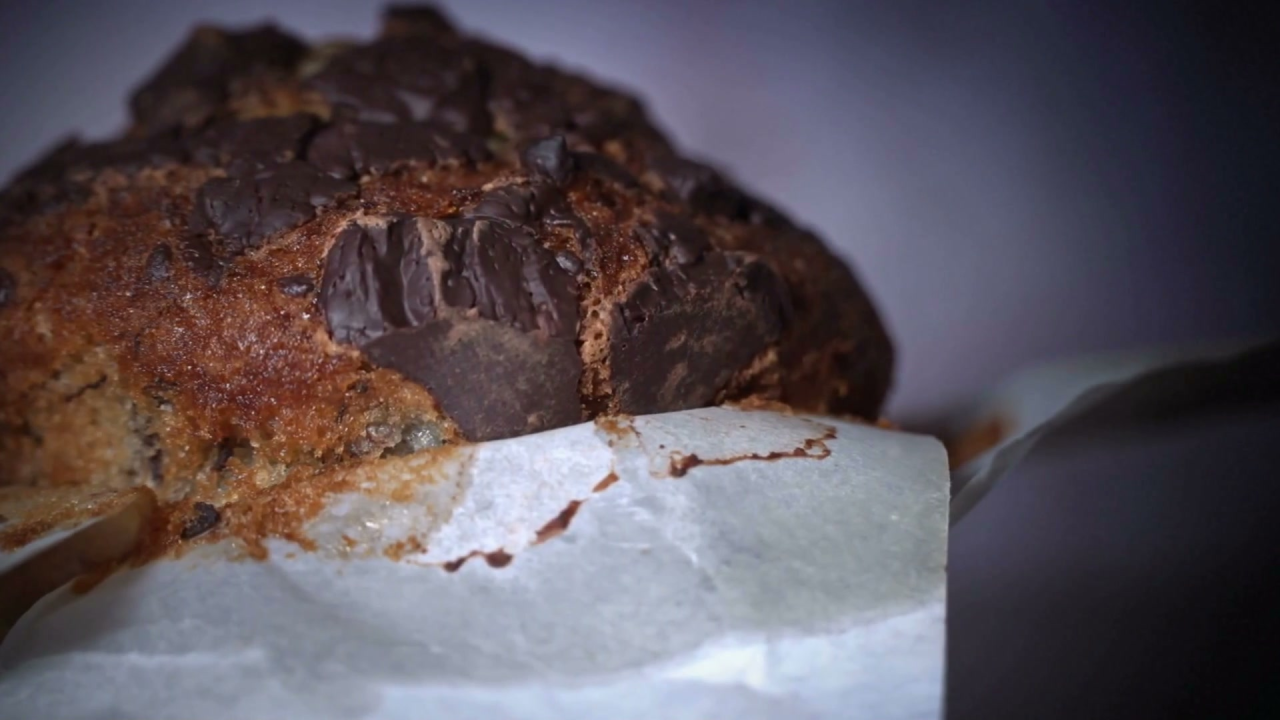A freshly baked chocolate chip muffin with melted chocolate chips on top